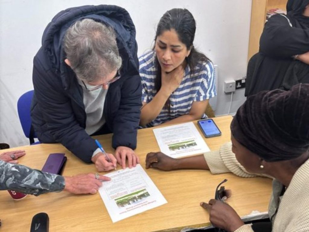 Roy Kitcher from RBH guiding participants on accessing heating vouchers during CAS Energy Week in Rochdale.