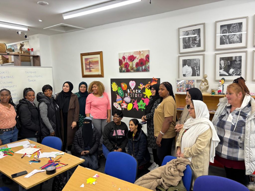CAS staff and community members celebrating Black History Month 2025 with a “Stand Firm in Power and Pride” poster at the CAS Hub in Rochdale