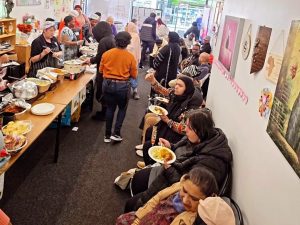 People enjoying food and conversation at a community cooking show event