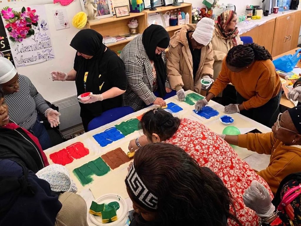 Women participating in a collaborative community art activity at CAS Rochdale, expressing creativity and connection