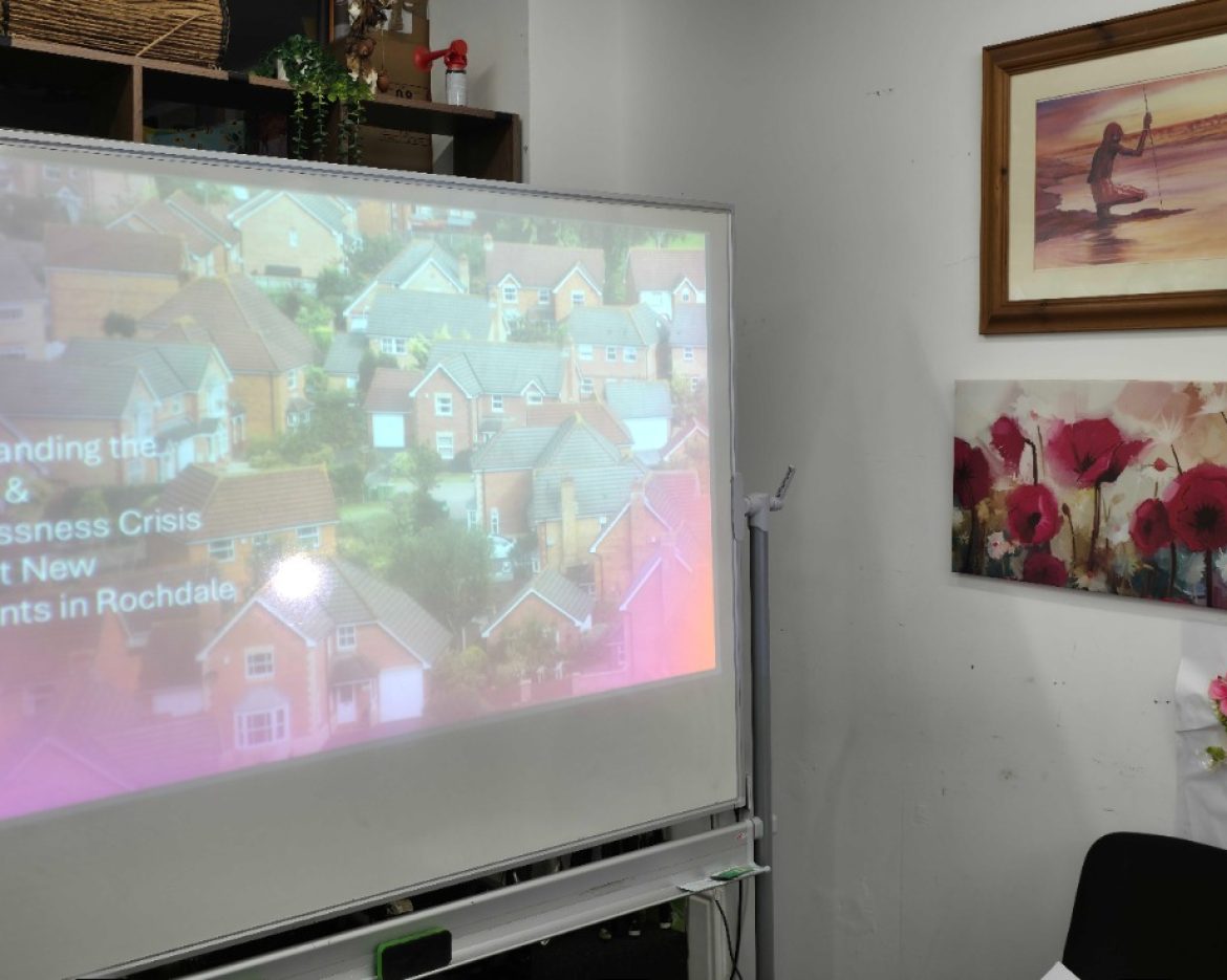 Screen display at the Hub showing the title of the Humanity Project Assembly on housing insecurity in Rochdale.